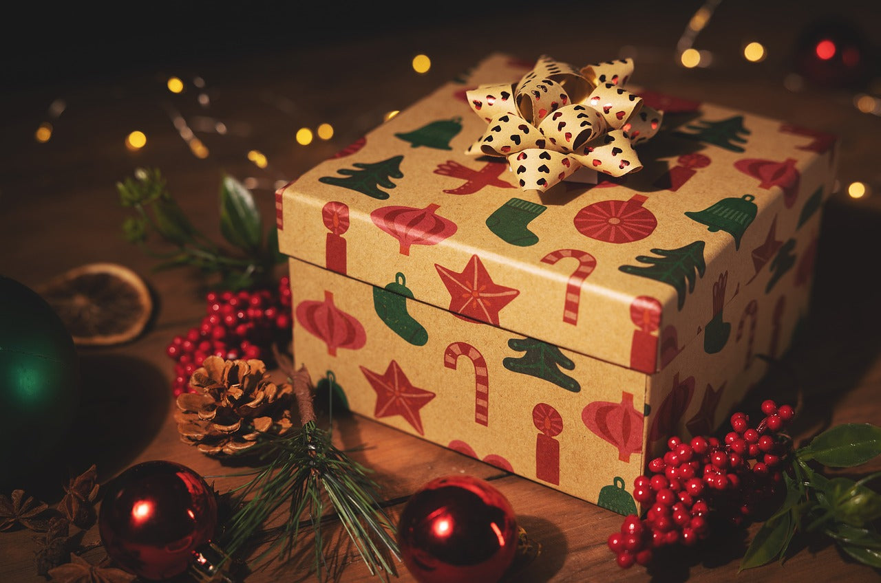 Julklapp med rosett under en gran